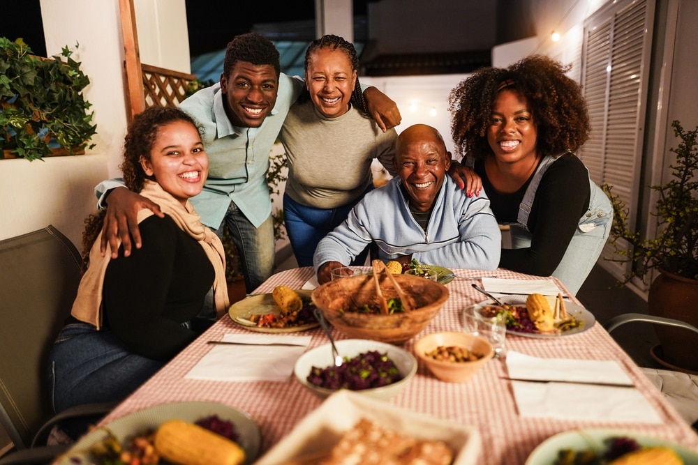 A family around a table, getting ready to enjoy a healthy, home-cooked meal.